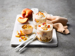 Peach flavored greek yogurt parfait recipe on plate with peaches